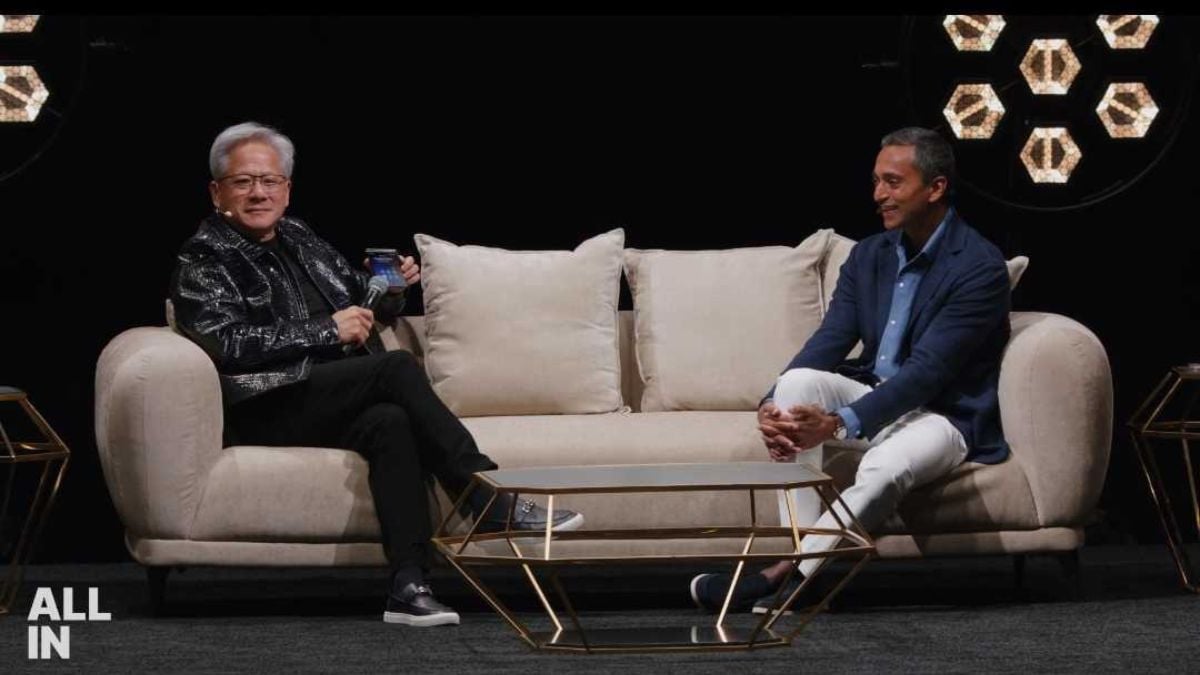 Jensen Huang holding his phone and a microphone onstage at the All-In Summit in Los Angeles, September 14, 2026